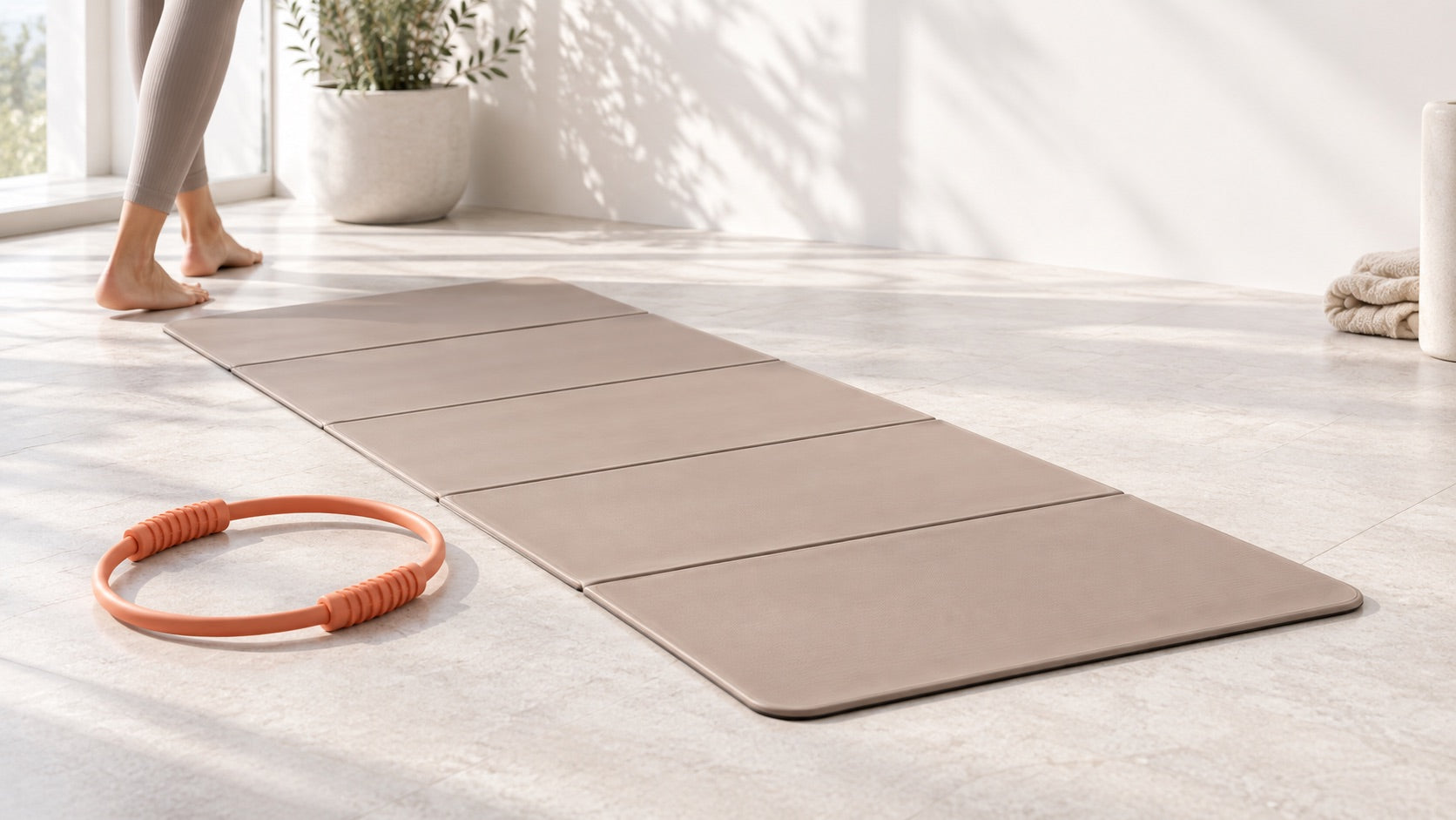 AKTIV91 foldable training mat and Pilates ring in a daylight studio scene