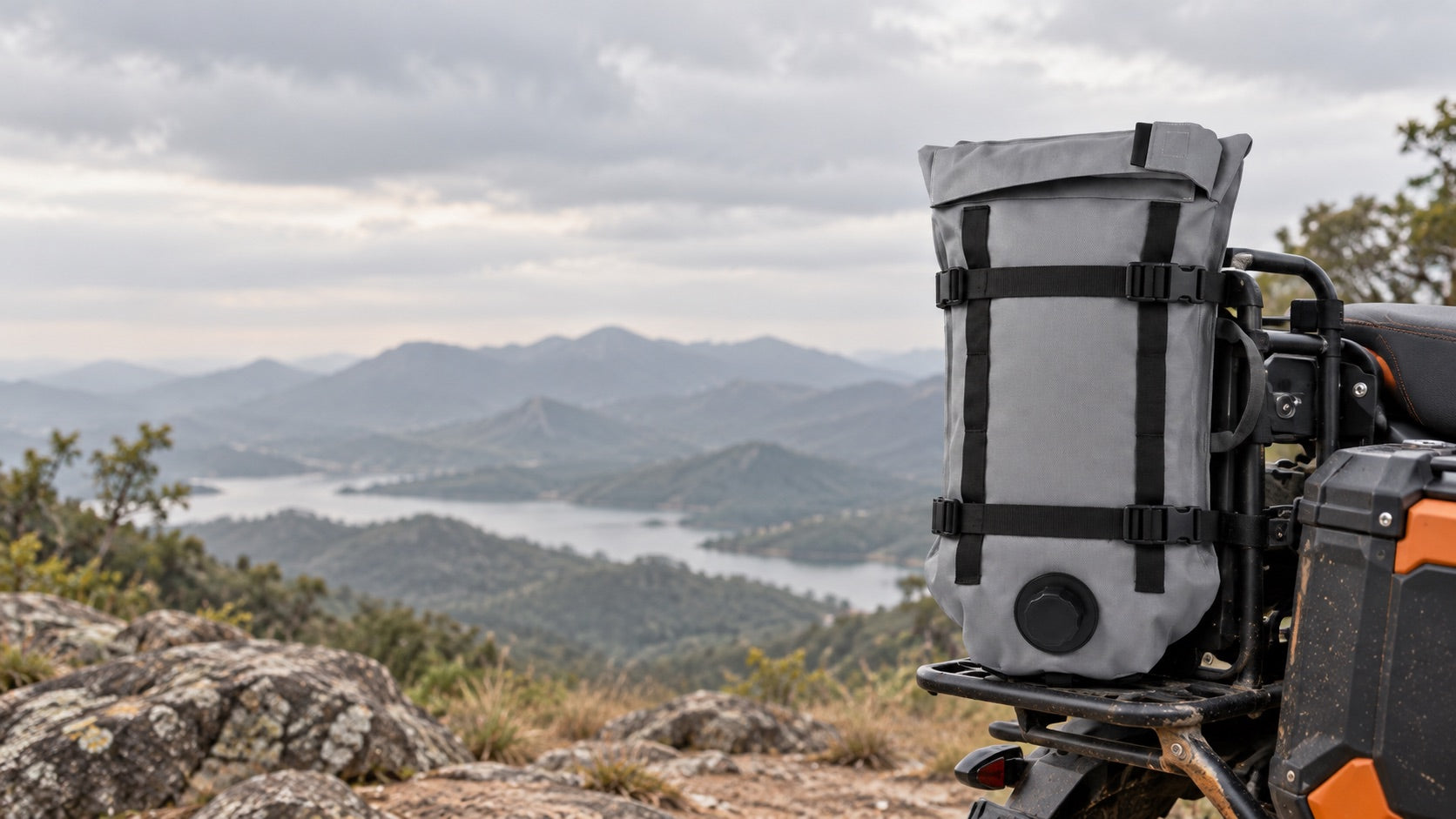 Editorial scene of a Range-X auxiliary fluid cell secured on a motorcycle at a trail overlook